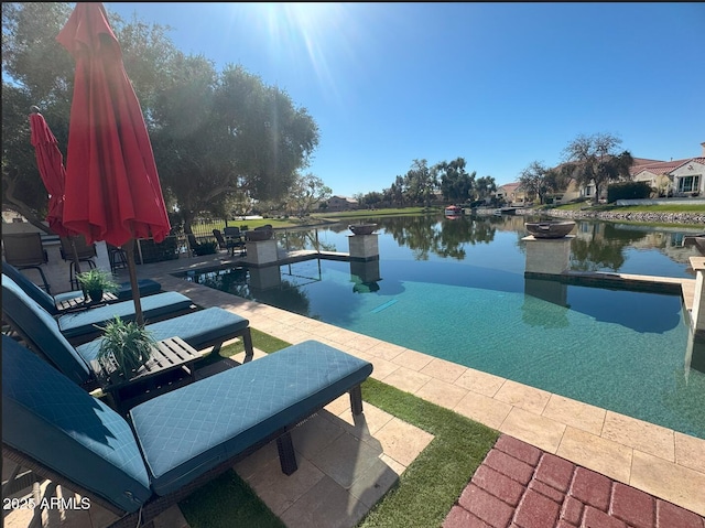 view of pool featuring a patio and a water view