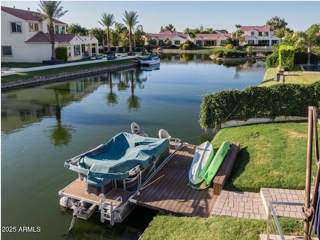 view of dock featuring a residential view, a water view, and a yard