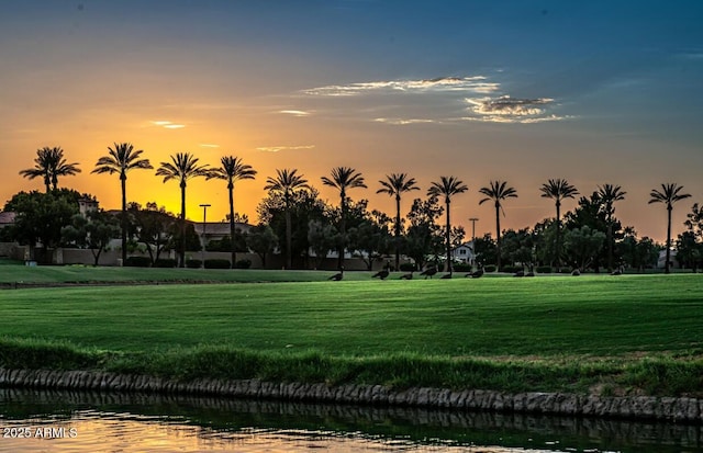 surrounding community featuring a water view and a lawn