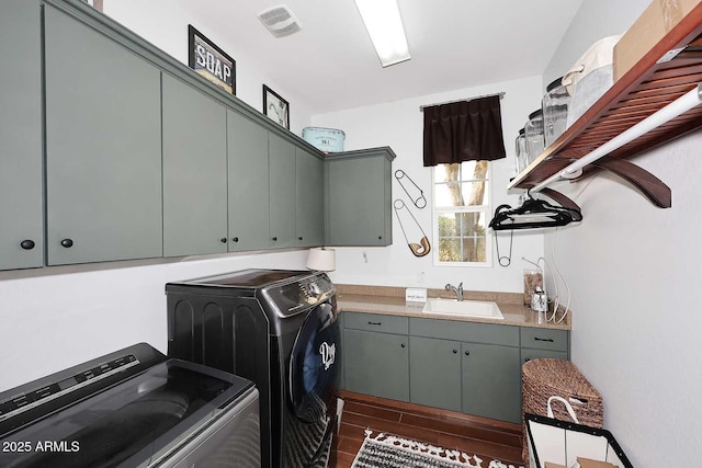 laundry room with visible vents, wood tiled floor, cabinet space, a sink, and washer and clothes dryer