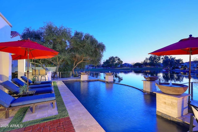 outdoor pool featuring a water view and a patio area