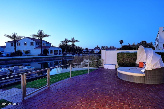 view of patio / terrace with fence and a water view