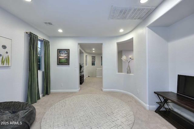 hallway featuring visible vents, baseboards, and carpet flooring