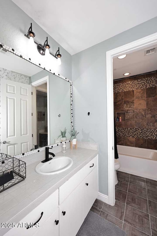 full bathroom with vanity, toilet, and visible vents