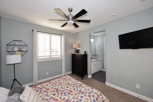 bedroom featuring ensuite bathroom, a ceiling fan, baseboards, and dark colored carpet