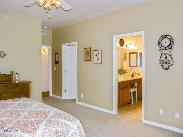 bedroom with connected bathroom, sink, and light colored carpet