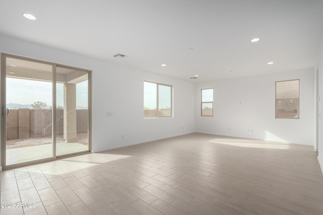 unfurnished room with light wood-style floors, baseboards, visible vents, and recessed lighting