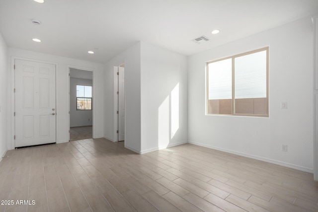 unfurnished room featuring light wood finished floors, baseboards, and recessed lighting