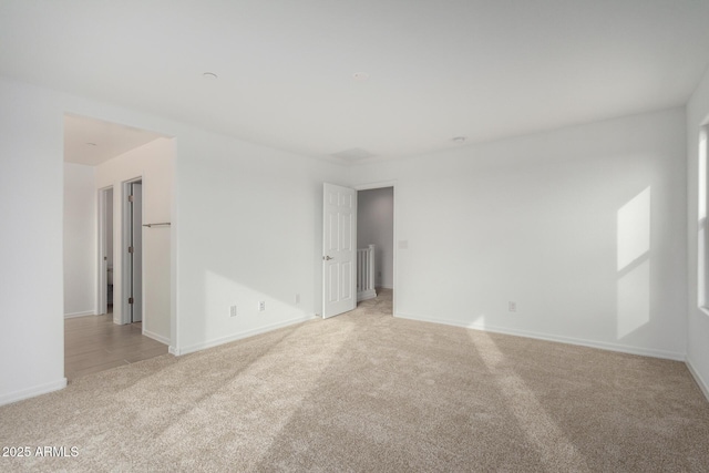 empty room with light carpet and baseboards