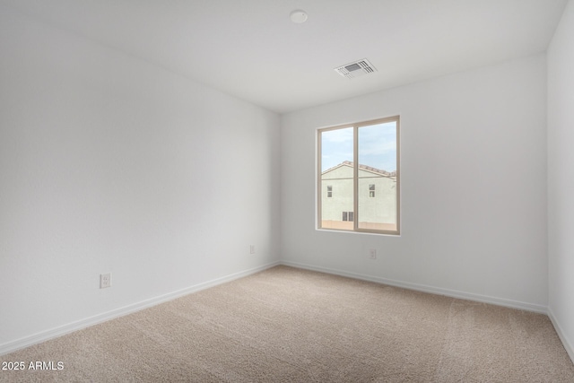 spare room featuring visible vents, light carpet, and baseboards