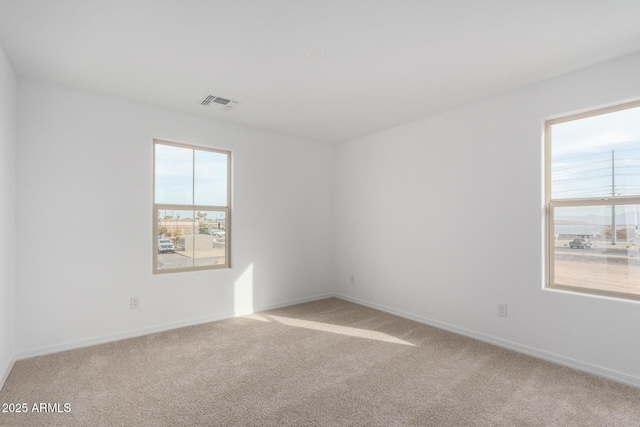 carpeted empty room with baseboards and visible vents