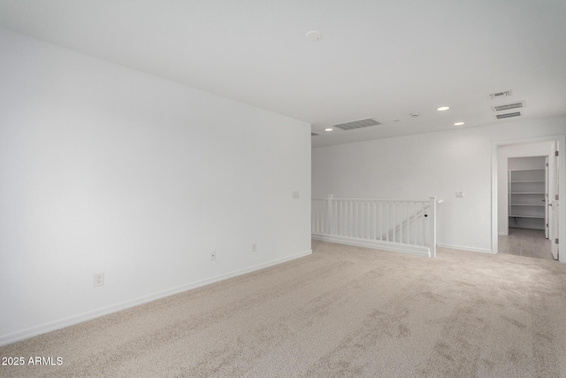 carpeted spare room with baseboards, visible vents, and recessed lighting