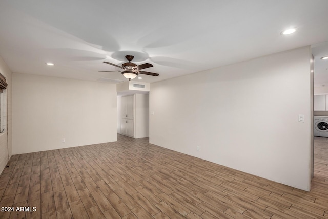 spare room featuring ceiling fan, light hardwood / wood-style floors, and washer / clothes dryer