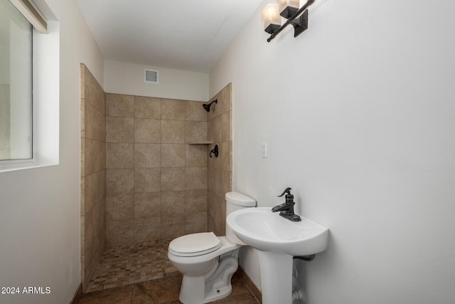 bathroom with tiled shower and toilet