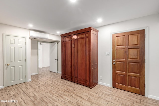 unfurnished room featuring light hardwood / wood-style flooring and a wall mounted AC