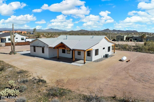 exterior space with cooling unit, a mountain view, and a patio