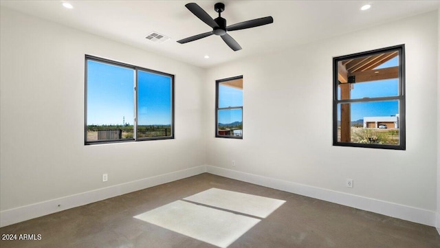 empty room with ceiling fan and concrete floors