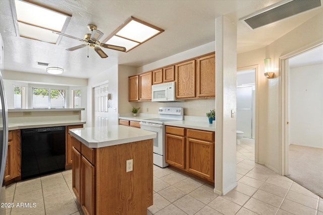 63 W Los Arboles Dr, Tempe, AZ 85284 - kitchen with white appliances, light tile patterned floors, a center island, light countertops, and visible vents