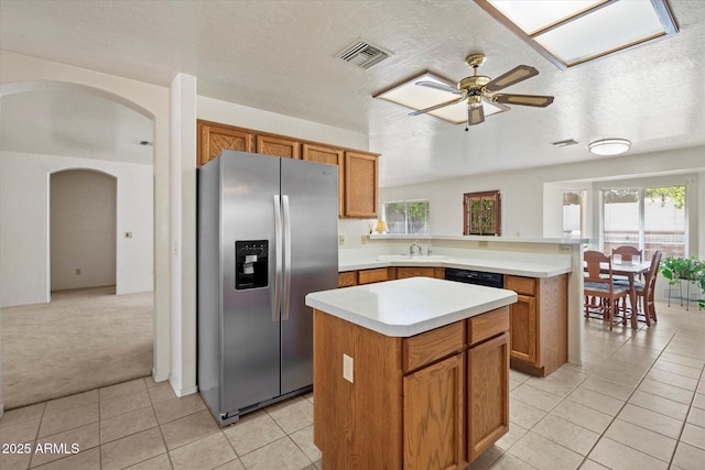 63 W Los Arboles Dr, Tempe, AZ 85284 - kitchen with arched walkways, a ceiling fan, visible vents, stainless steel refrigerator with ice dispenser, and a sink