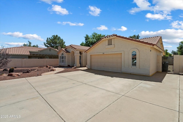 63 W Los Arboles Dr, Tempe, AZ 85284 - mediterranean / spanish-style house featuring stucco siding, driveway, a garage, a tiled roof, and a gate