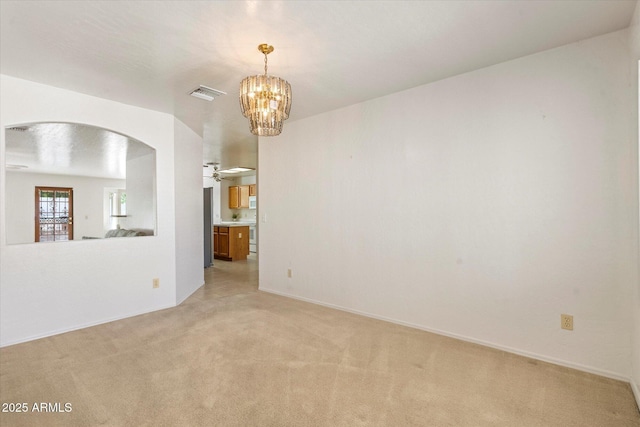 63 W Los Arboles Dr, Tempe, AZ 85284 - spare room featuring baseboards, light carpet, a chandelier, visible vents, and arched walkways