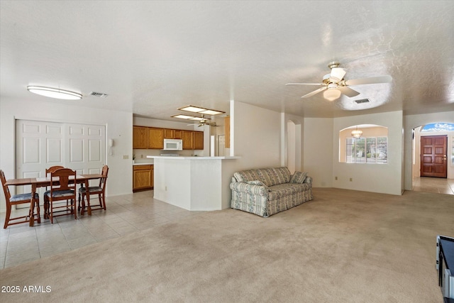 63 W Los Arboles Dr, Tempe, AZ 85284 - living room with visible vents, ceiling fan, light tile patterned flooring, and light carpet