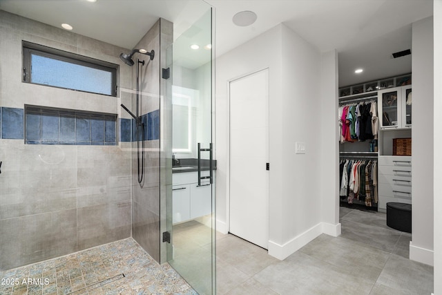 bathroom with a shower with shower door and sink