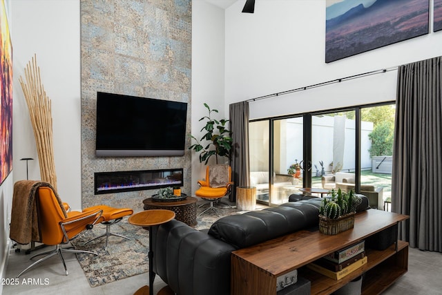 living room with a fireplace, french doors, and a towering ceiling