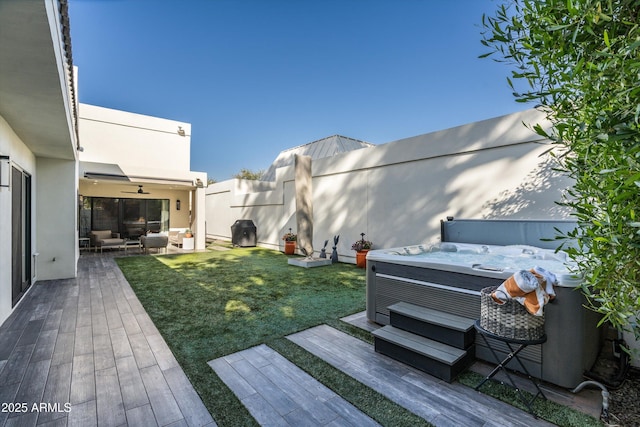 view of yard with outdoor lounge area, a wooden deck, and a hot tub