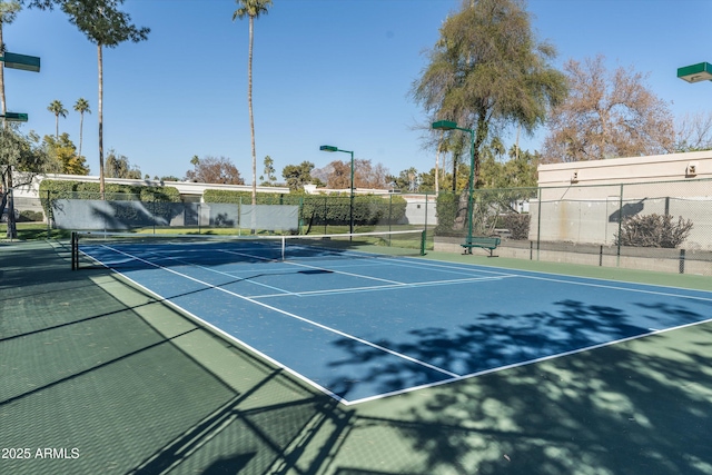 view of tennis court with basketball hoop