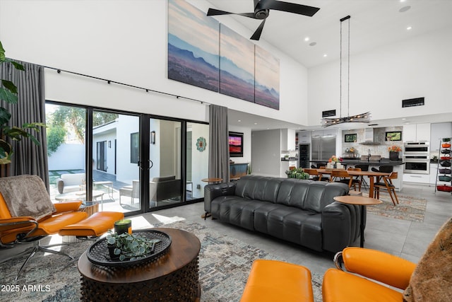 living room with a towering ceiling and ceiling fan