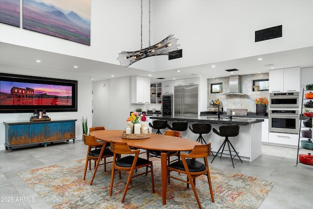 dining area with sink and a high ceiling