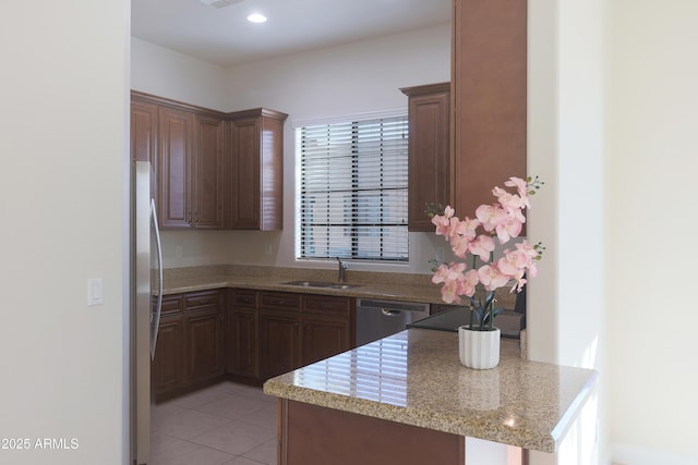 kitchen with a peninsula, light tile patterned flooring, recessed lighting, a sink, and stainless steel appliances