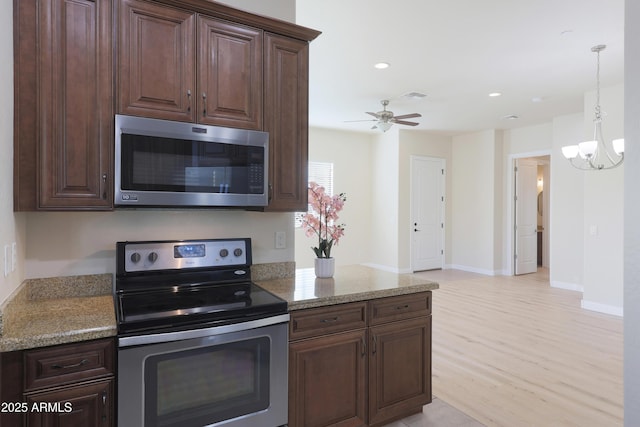 kitchen featuring light wood-type flooring, visible vents, stainless steel appliances, dark brown cabinetry, and light stone countertops