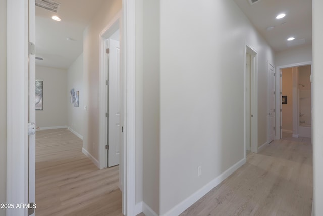 corridor featuring recessed lighting, visible vents, baseboards, and light wood finished floors