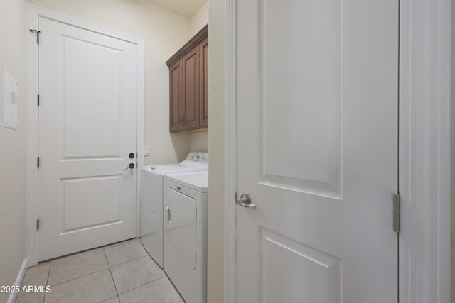 washroom with light tile patterned floors, cabinet space, and separate washer and dryer