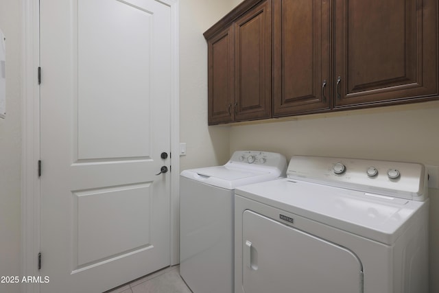 washroom with cabinet space, light tile patterned floors, and independent washer and dryer