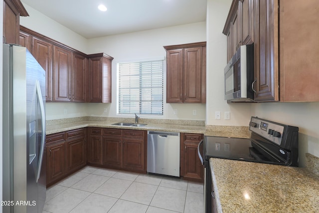 kitchen with light stone counters, recessed lighting, light tile patterned flooring, stainless steel appliances, and a sink