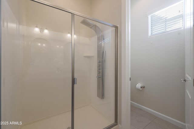 bathroom featuring tile patterned floors, baseboards, and a shower stall