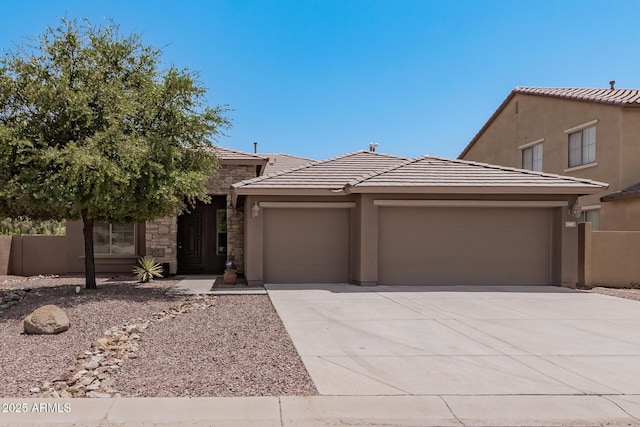 view of front facade with stucco siding, concrete driveway, an attached garage, stone siding, and a tiled roof