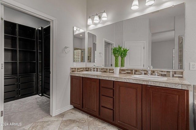 full bath with double vanity, visible vents, and a sink