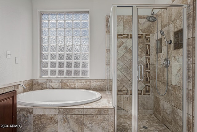 bathroom with a stall shower and a garden tub