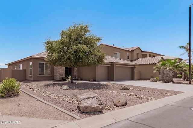 view of front of home with concrete driveway, a tile roof, and stucco siding