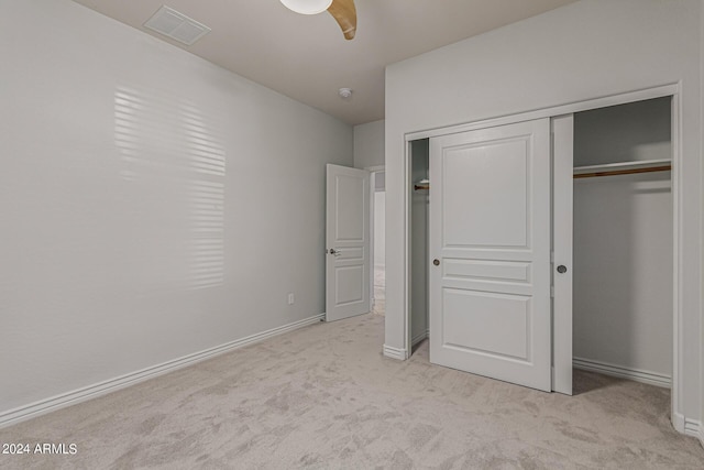 unfurnished bedroom featuring baseboards, a closet, visible vents, and light colored carpet