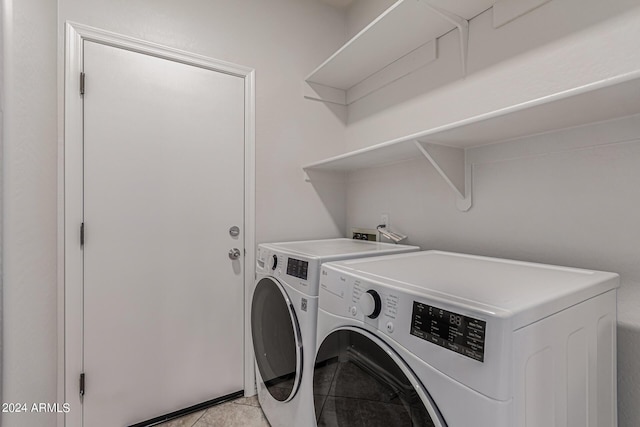 washroom featuring light tile patterned floors, laundry area, and washing machine and clothes dryer