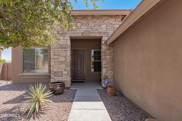 property entrance with stone siding and stucco siding