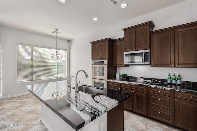 kitchen featuring hanging light fixtures, a kitchen island with sink, visible vents, and stainless steel appliances