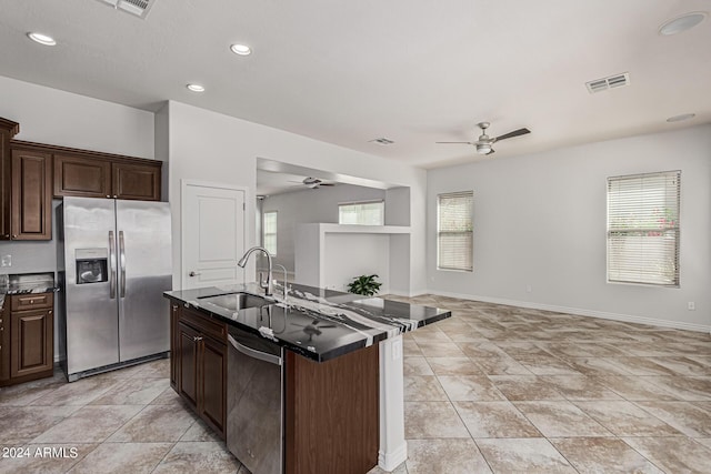 kitchen featuring dark countertops, visible vents, appliances with stainless steel finishes, and a sink