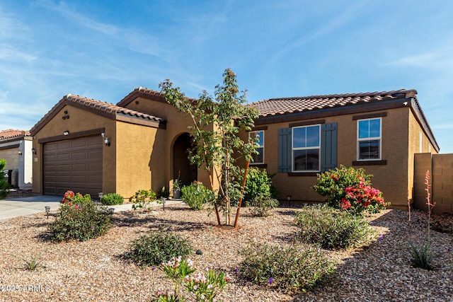 mediterranean / spanish home featuring an attached garage, concrete driveway, stucco siding, and a tile roof