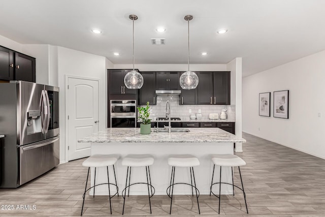 kitchen with a kitchen breakfast bar, backsplash, visible vents, and stainless steel appliances